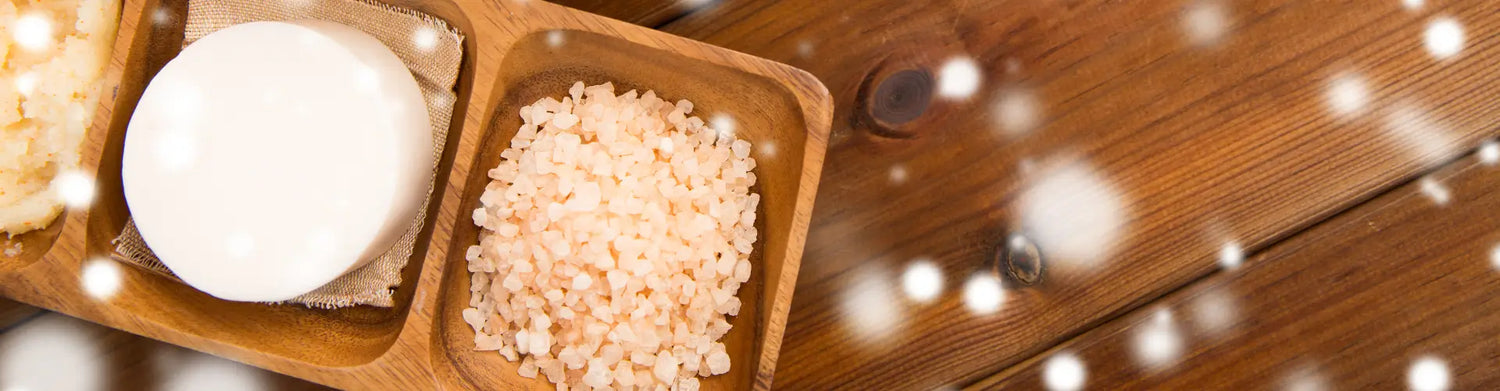 Wooden tray with a white stone and pink salt, representing Salt Therapy.